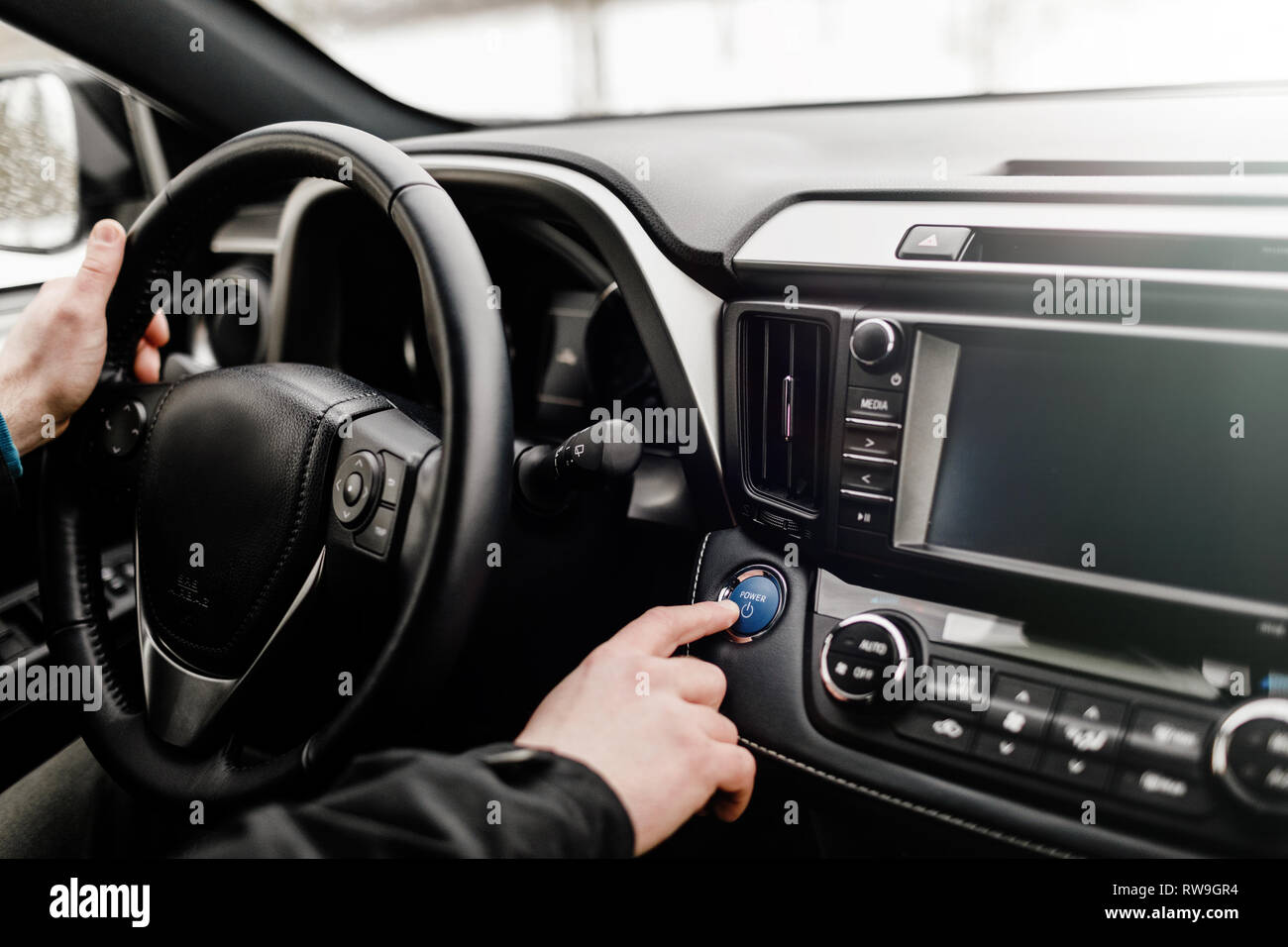 Treiber drücken auto motor start-stop-Taste in einem modernen Auto. Stockfoto