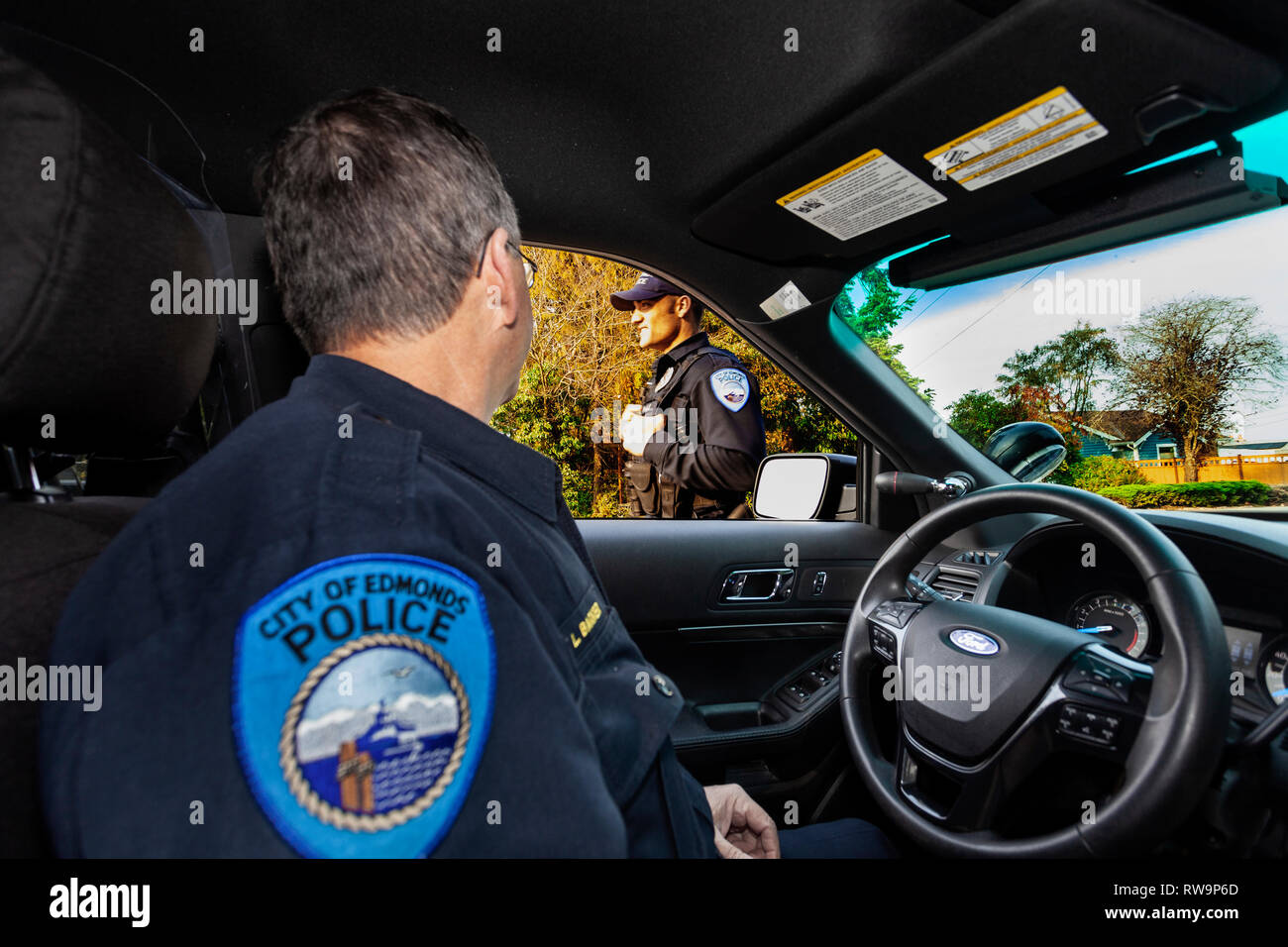 PE 00376-00 ... WASHINGTON - Sergeant Robert Barker der Edmonds Polizei talkes mit einem anderen Offizier während auf Patrouille. Stockfoto