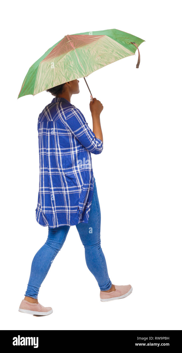 Rückseite des dunkelhäutigen Mädchen in einem T-Shirt zu Fuß unter einem Schirm. Rückseite Ansehen der Person. Ansicht von hinten leute Sammlung. Über weiß zurück Isoliert Stockfoto