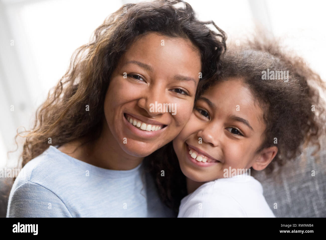 Portrait von gemischten Rennen Mama und Tochter Umarmung zu Hause Stockfoto