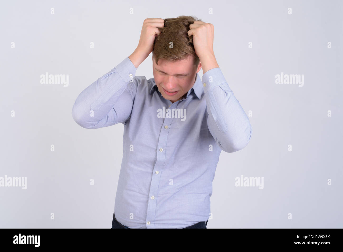 Porträt der jungen betonte blond Geschäftsmann Haare herausziehen Stockfoto