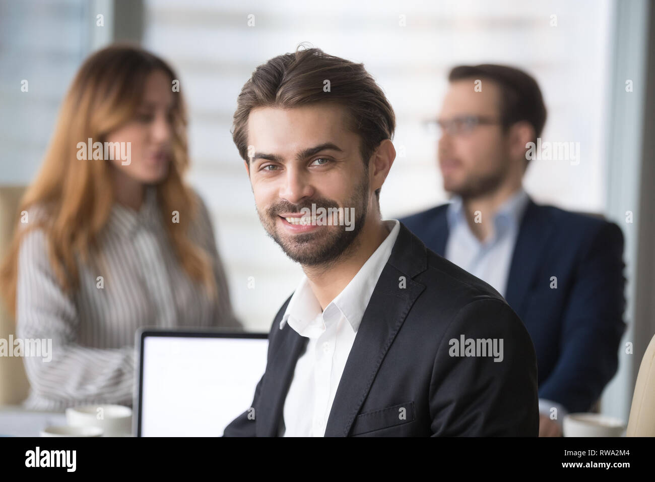 Lächelnd Geschäftsmann in Anzug auf Kamera posiert bei der Sitzung Stockfoto