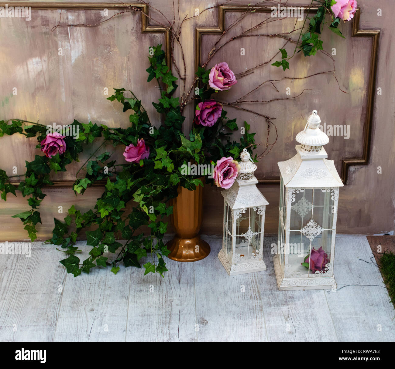 Studio Dekor. Blumen an den Wänden. Vase mit Blumen und einer Laterne. Stockfoto