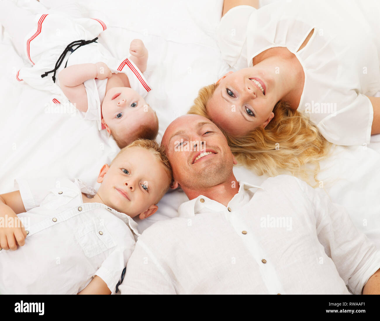 Happy Family auf dem Boden liegend mit den Köpfen zusammen Stockfoto