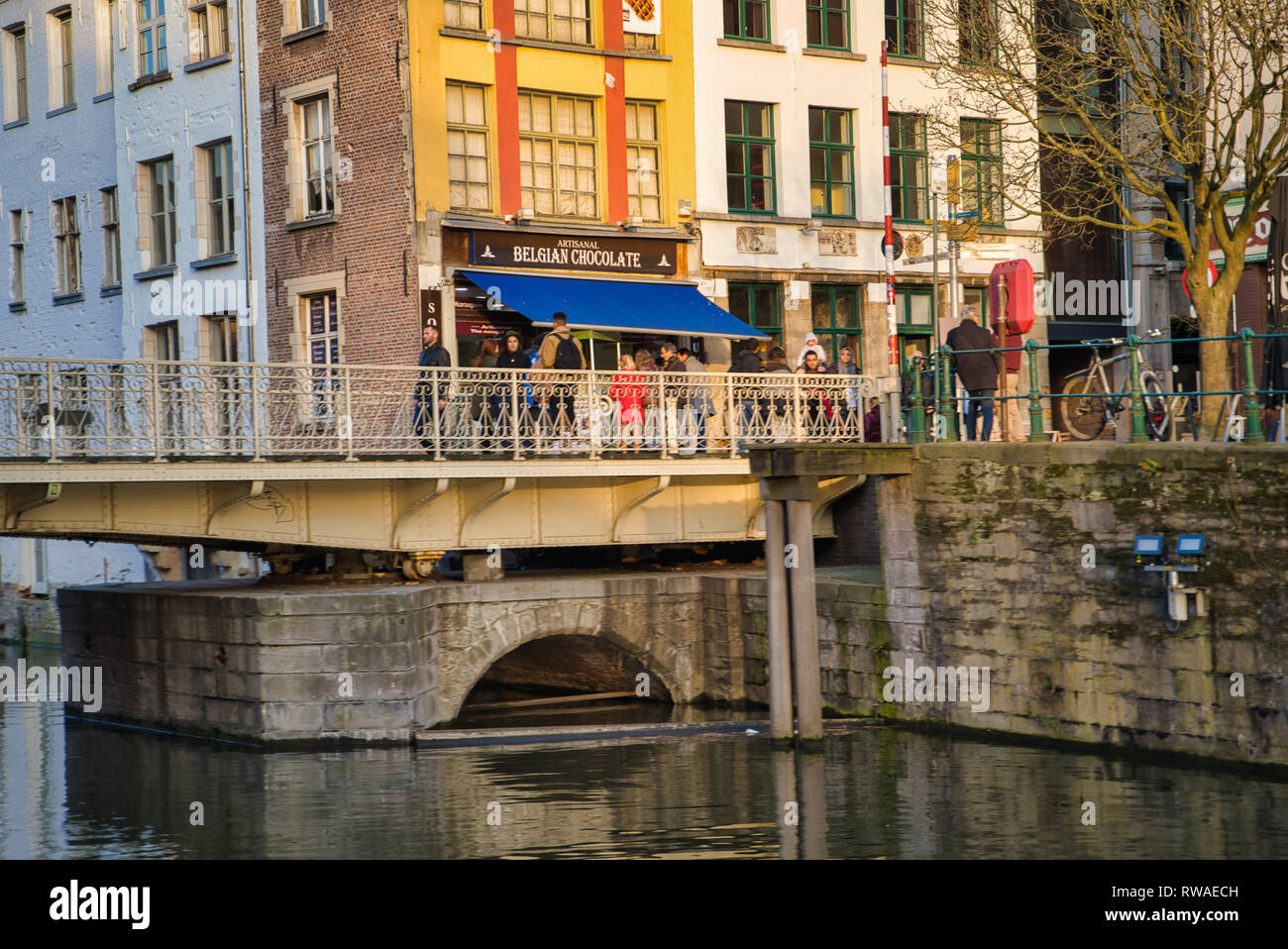 GENT, Belgien - 17. FEBRUAR 2019: Shop belgischer Schokolade. Brücke über den Fluss Lys Stockfoto