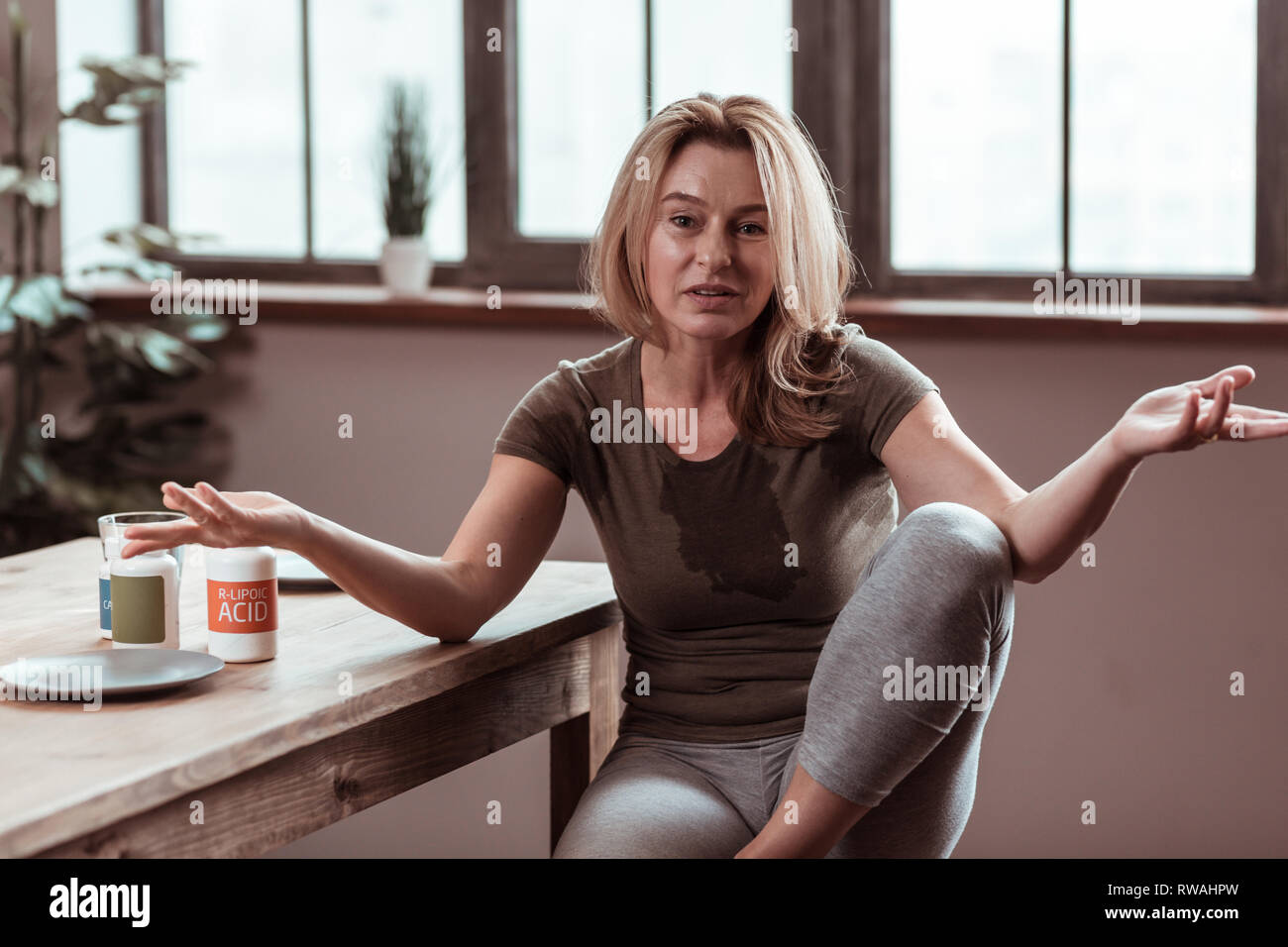 Betrunkene blonde Frau verschütten auf t-shirt Stockfoto