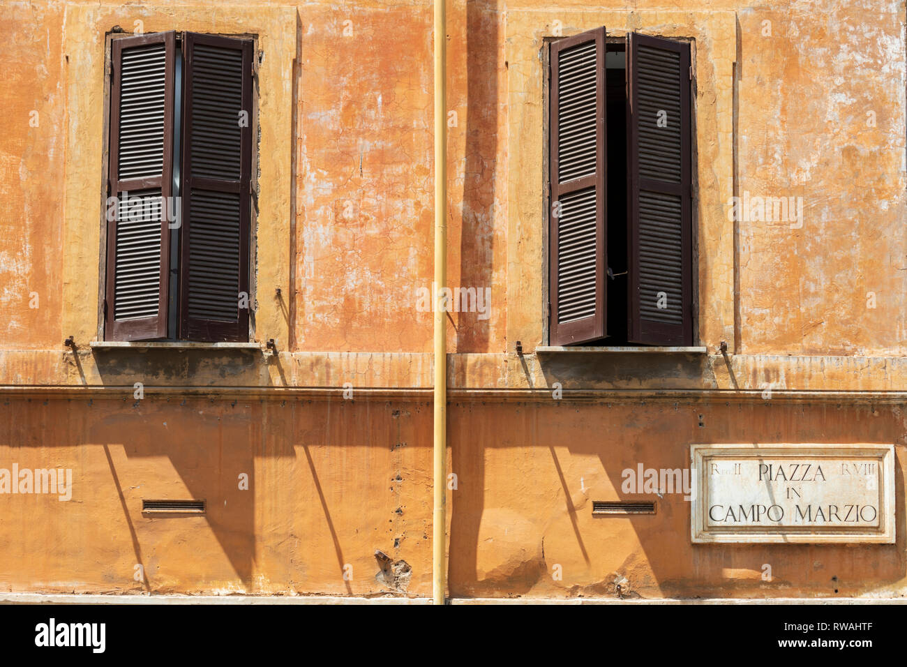 Öffnen Fensterläden in einem verwitterten Mauer in Rom, Italien. Stockfoto