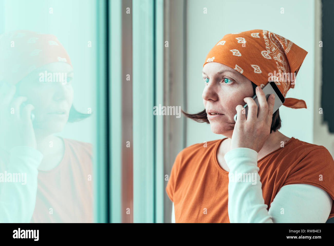 Hoffnungsvolle weibliche Tischler Gespräch am Handy, während durch die Fenster Ihres kleinen Unternehmens Holzarbeiten Workshop suchen Stockfoto