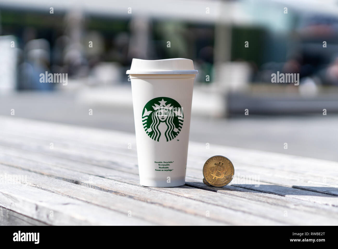 Cryptocurrency Bitcoin neben Starbucks Tasse. Starbucks Annahme des blockchain Konzept - Slowenien - 28.2.2019 Stockfoto