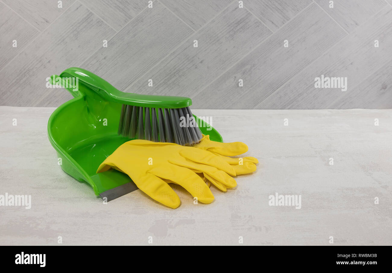 Reinigung von Werkzeugen wie Schaufel und Handschuhe in Grün und Gelb Stockfoto