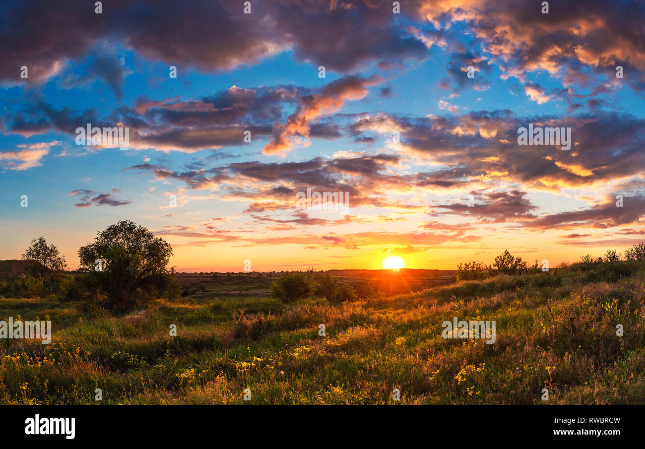Sommer helle Landschaft. Bewölkter Sonnenuntergang über der Steppe Hügel. Bewölkter Himmel und Sonnenlicht. Die ukrainische Landschaft. Kriviy Rih Stockfoto