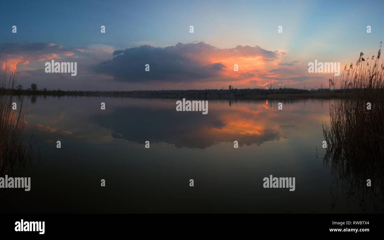 Ein Gewitter einsame Wolke von Abendsonne hervorgehoben und wieder aus dem Wasser. Ein fluss auf den Sonnenuntergang. Kriviy Rih, Ukraine Stockfoto