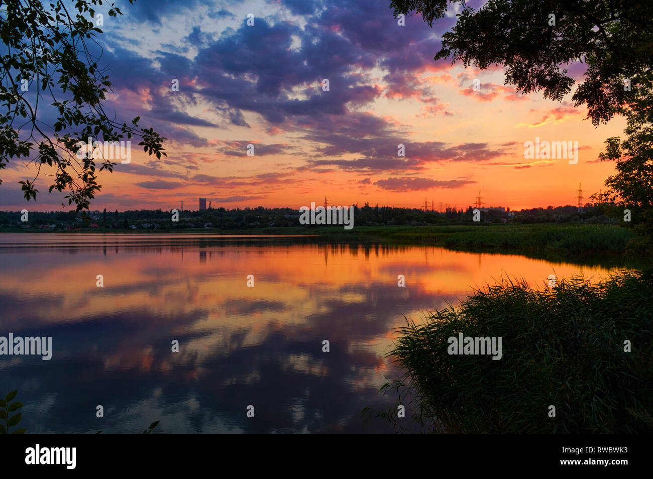 Super Sommer Landschaft Sonnenuntergang durch Wasser in Kriwoi Rog, Ukraine wider. Einen schönen Sonnenuntergang Himmel Hintergrund. Farbenfroher Sonnenuntergang Wolken. Stockfoto