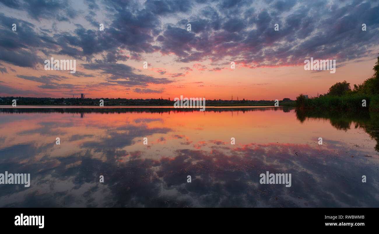 Sommer Sonnenuntergang Landschaft, Fluss Landschaft, Wolken von noch Wasser in Kriwoi Rog, Ukraine wider. Stockfoto