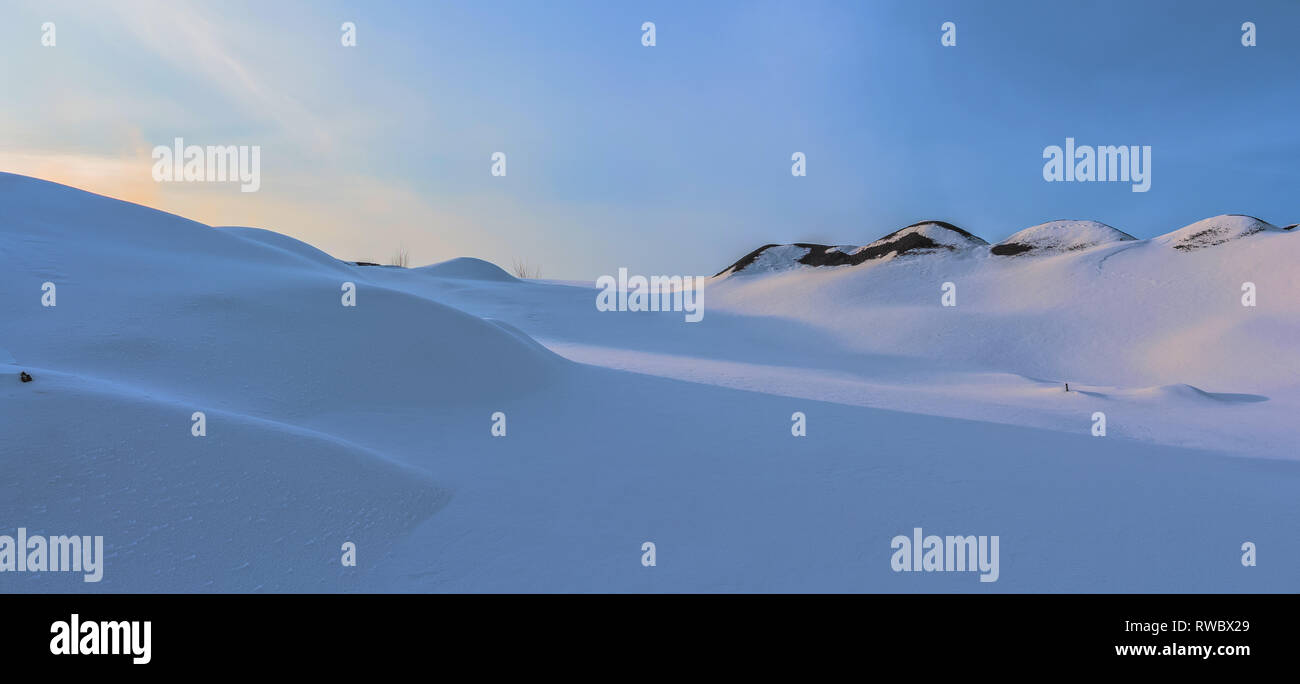 Winterlandschaft an der Tageszeit in Kriwoi Rog, Ukraine. Berge von Schnee bedeckt. Landschaft auf dem Hintergrund des blauen Himmels. Schnee Landschaft der Wüste. Stockfoto