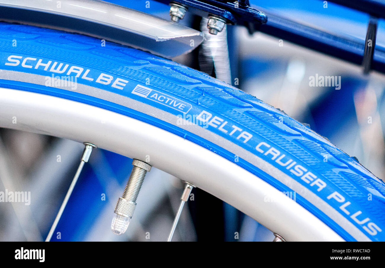 01. März 2019, Niedersachsen, Oldenburg: Die Schwalbe Logo und der  Aufschrift "Delta Cruiser Plus" werden in einem blauen Fahrrad Reifen  gedruckt. Ralf Bohle GmbH produziert Reifen und Schläuche für Fahrräder und  Rollstühle