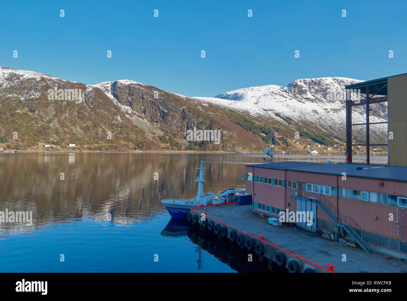 Blick über den Fjord von der Batbygg Werft in Maloy auf einer frühen Winter morgen mit schneebedeckten Bergen im Hintergrund. Norwegen. Stockfoto