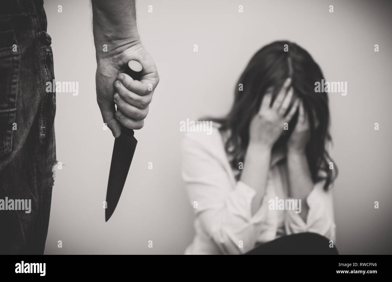 Mann mit Messer zu seiner Frau zu kommen. Home Gewalt Konzept. Stockfoto