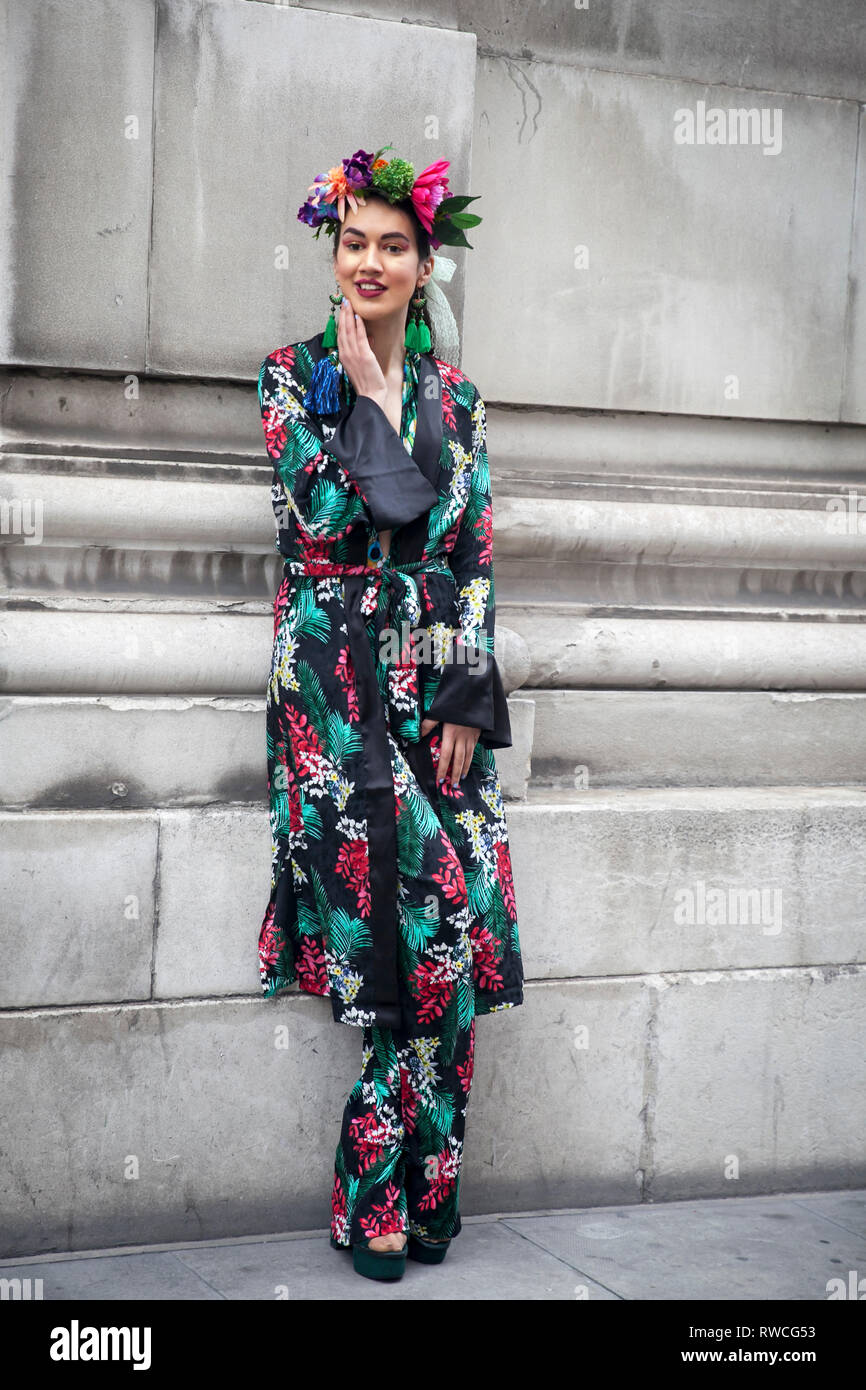 LONDON - 15. FEBRUAR 2019: Stilvolle Teilnehmer sammeln außerhalb 180 The Strand für die London Fashion Week. Ein Mädchen in eine schwarze silk Robe mit weiß-grün-r Stockfoto