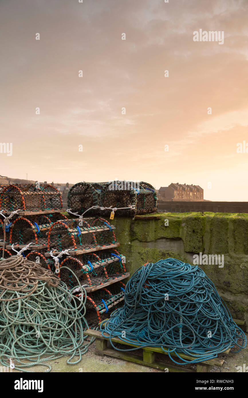 Angelausrüstung (Seile und Reusen) Gegen die Hafenmauer in der aberdeenshire Dorf Gourdon gestapelt Stockfoto