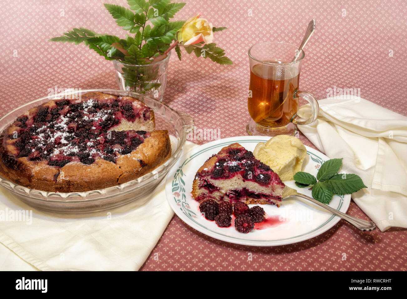 Hausgemachte wilde Beeren und Kuchen mit Kaffee- und Rose Blume auf rosa Tischdecke Stockfoto