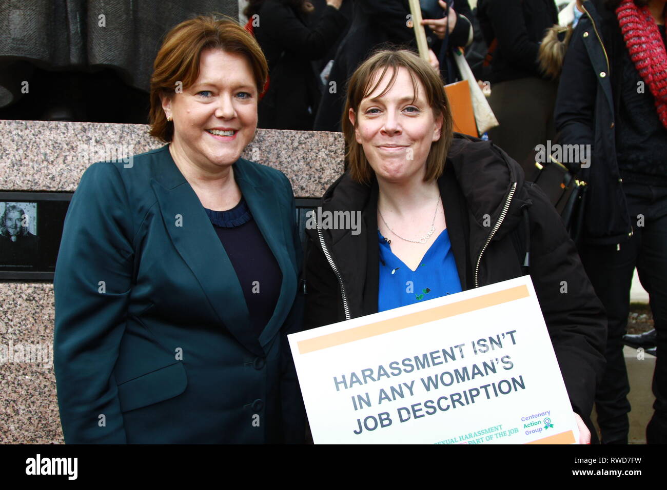 Maria Miller [konservative] und Jess Phillips [Arbeitsmarkt] stehen zusammen in Parliament Square, Westminster während der Teilnahme an und Unterstützung von März 4 Frauen und der muslimischen Frauen Netzwerk UK. Am 5. März 2019. Schild mit den Worten Belästigung nicht in Job Beschreibung für jede Frau ist gehalten wird. Die britischen Politiker. Britische Politiker. Politik. März 4 Frauen. Stockfoto