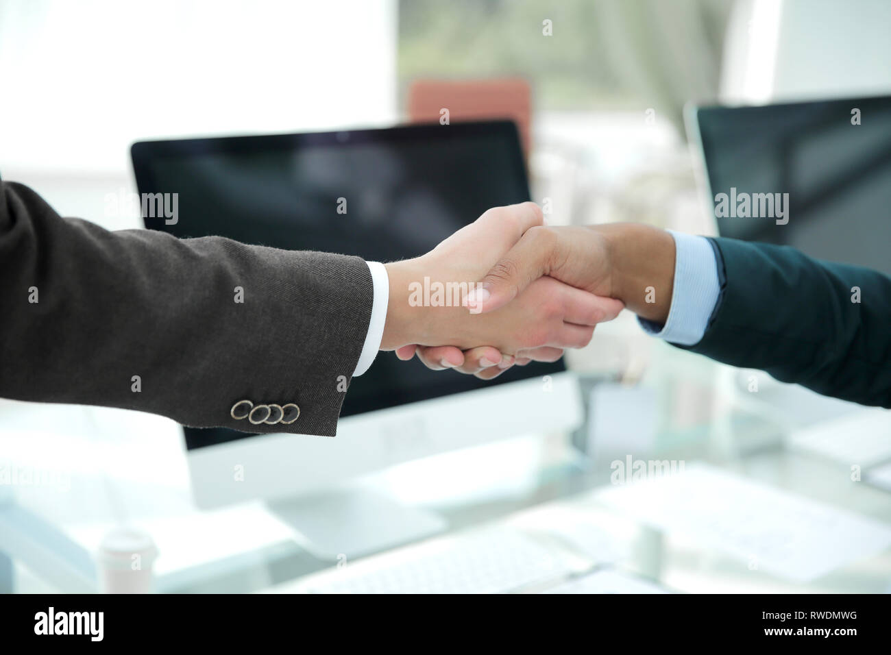 Handshake finanziellen Partner über einen Schreibtisch im Büro Stockfoto