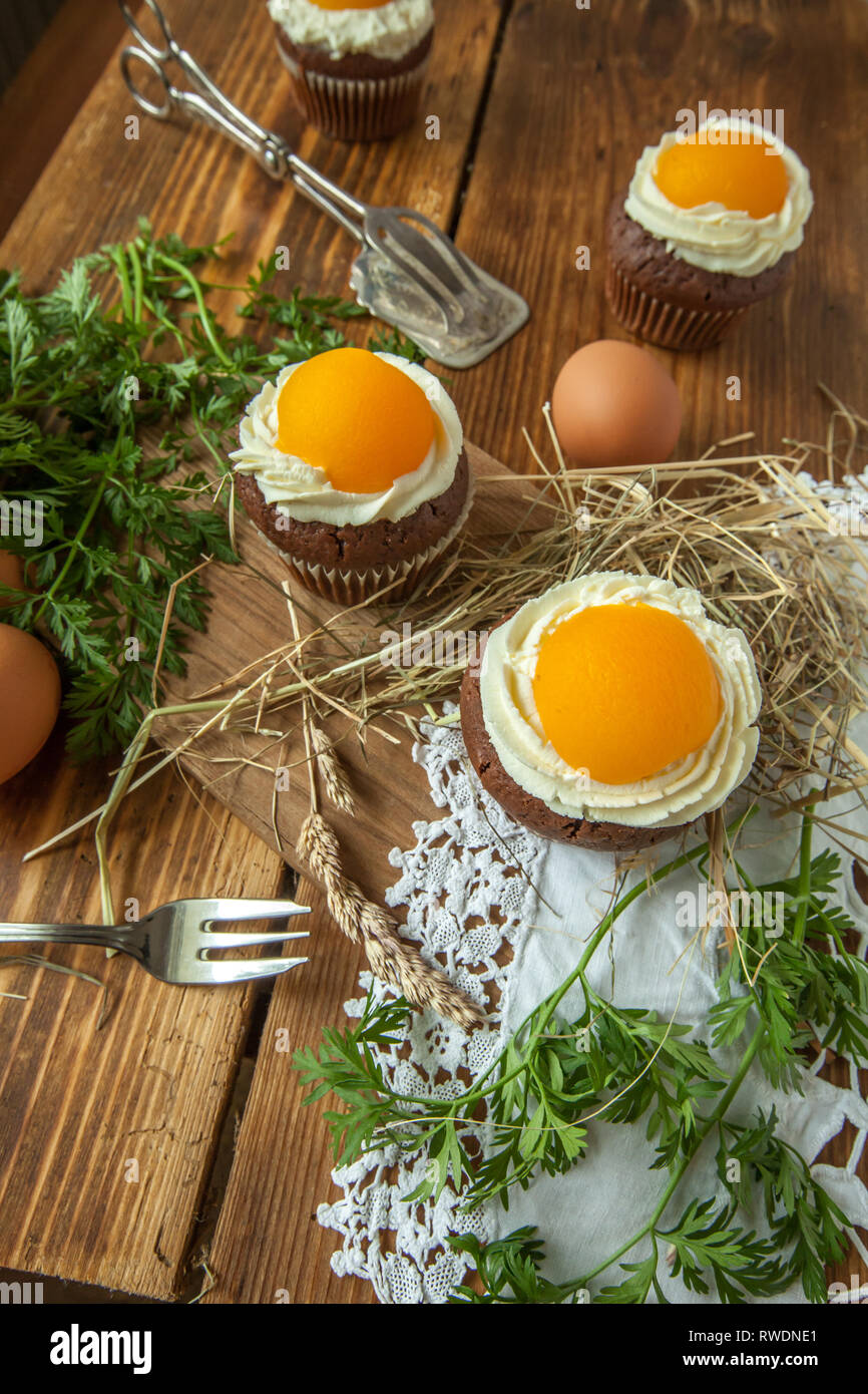 Ostern Cupcake auf Holzuntergrund mit Pfirsich sieht aus wie ein Spiegelei Stockfoto