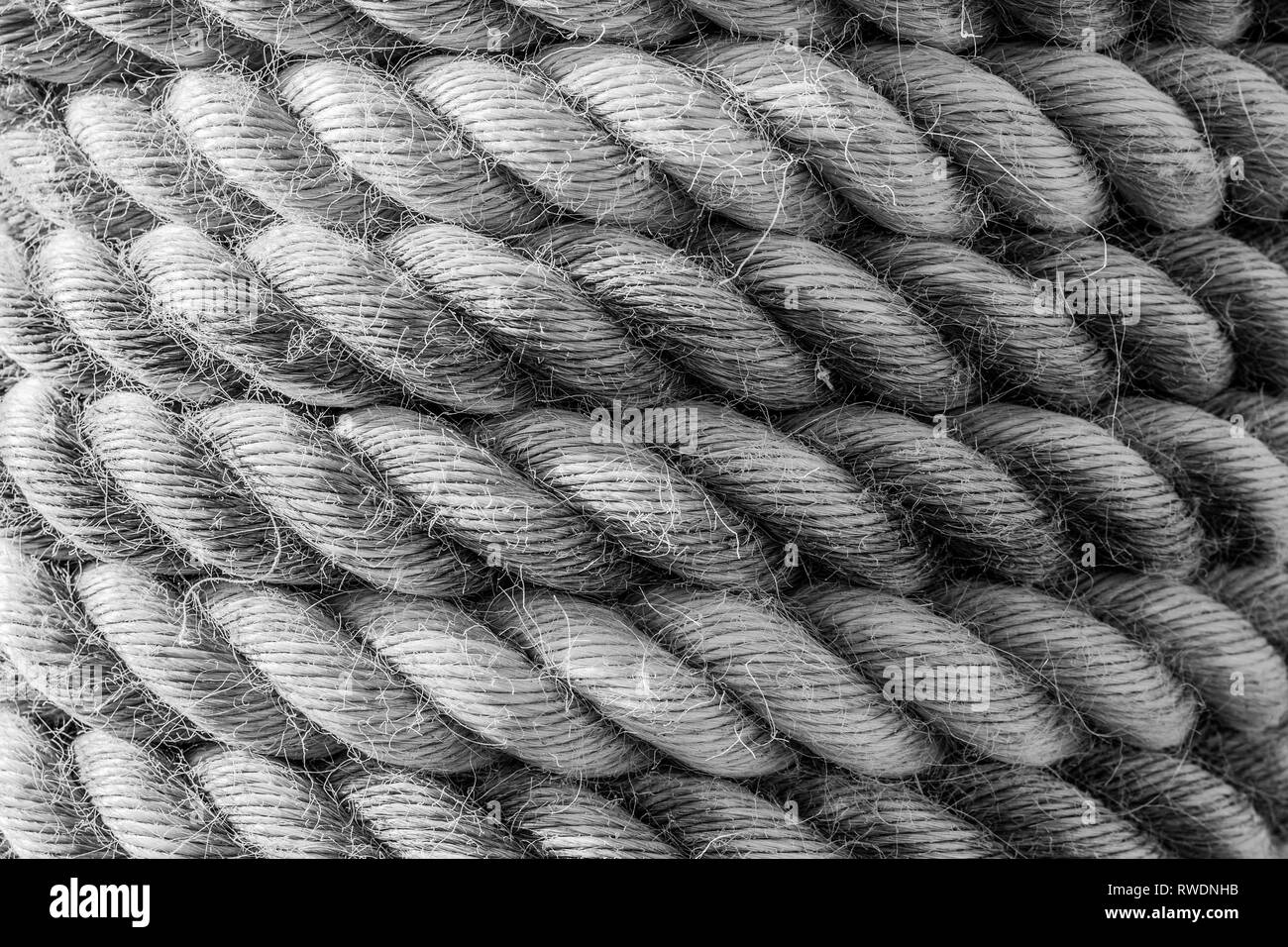Einen strukturierten Hintergrund der Spulen von dicken und schweren industriellen Seil, ausgefranst ist, abgenutzt und verwittert und von Schiffen in der Schifffahrt zu Moor Stockfoto