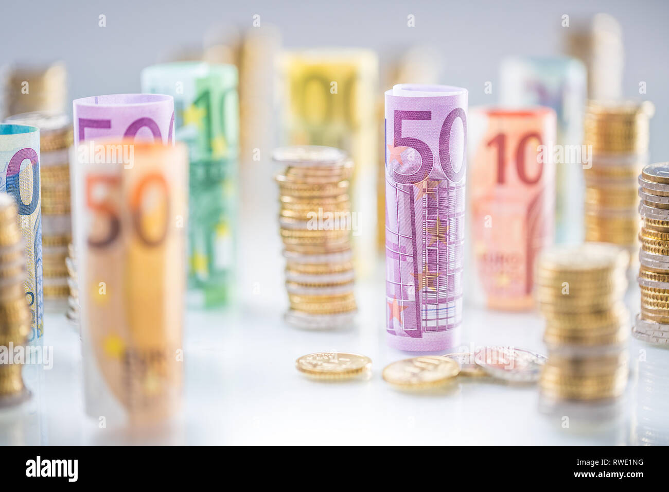 Gerollt Euro-Banknoten und -münzen Türme in anderen Positionen gestapelt Stockfoto