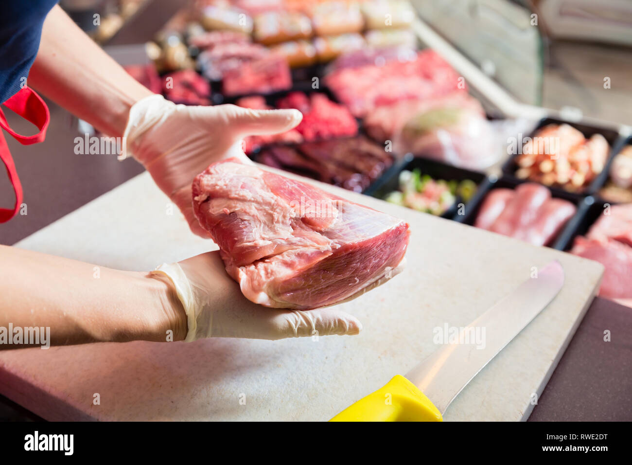 Frau in Metzgerei verkaufen Fleisch Filet Stockfoto
