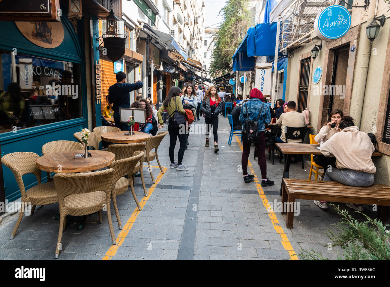 Izmir, Türkei - März 2, 2019. Schmale cafe gesäumten Straße im Viertel Alsancak Izmir, mit Gewerbe und Menschen. Stockfoto