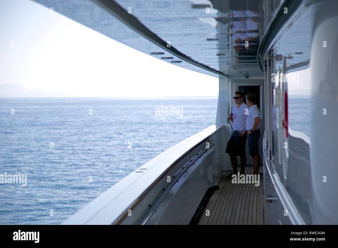 In der breiten Ansicht von 2 Superyacht Crew in Uniform auf Deck reden, Meer Hintergrund Stockfoto