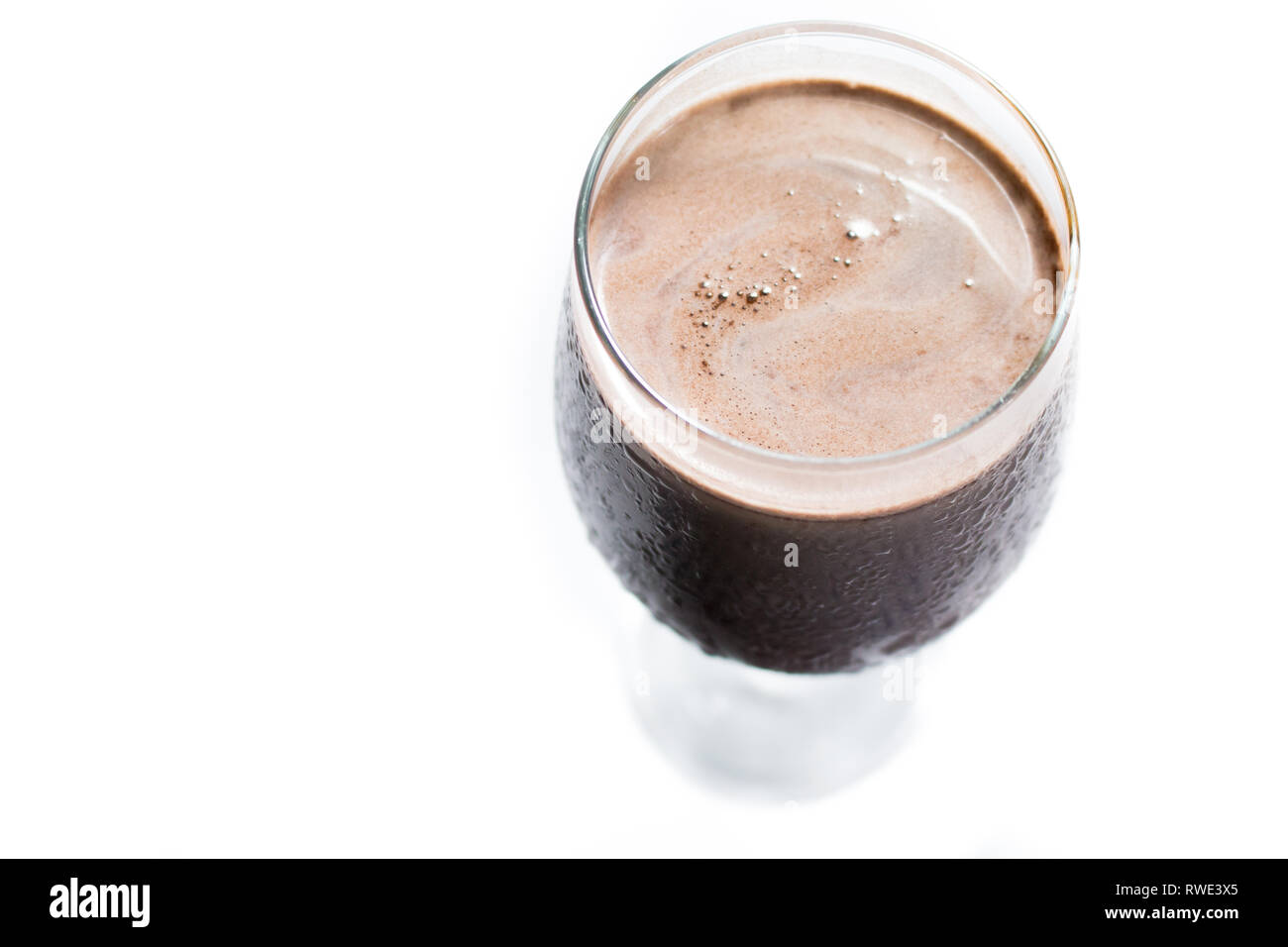 Blick von oben auf das Schwitzen Glas Schokolade Milchshake in einem weißen Hintergrund. Leckere kalte Schokolade trinken Stockfoto