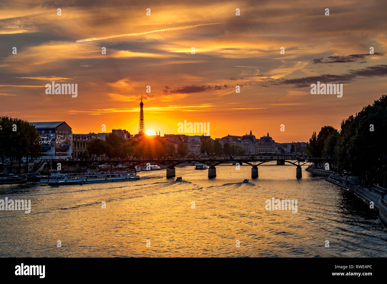 Paris und die seine, die bei Sonnenuntergang unter der Pont des Art fließt, mit dem Eiffelturm in der Ferne, Paris, Frankreich Stockfoto