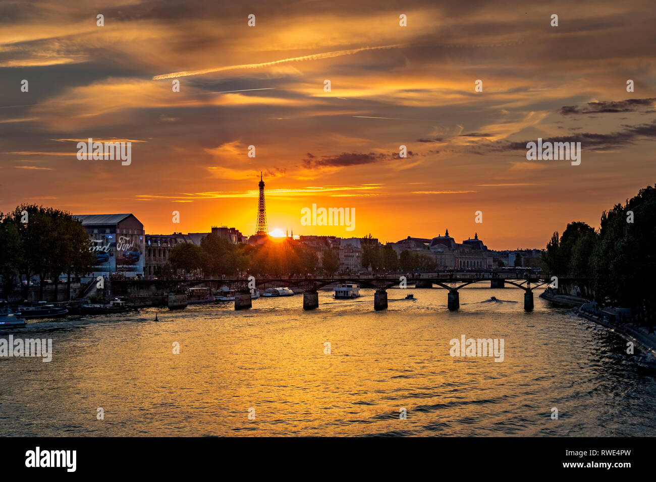 Paris und die seine, die bei Sonnenuntergang unter der Pont des Art fließt, mit dem Eiffelturm in der Ferne, Paris, Frankreich Stockfoto