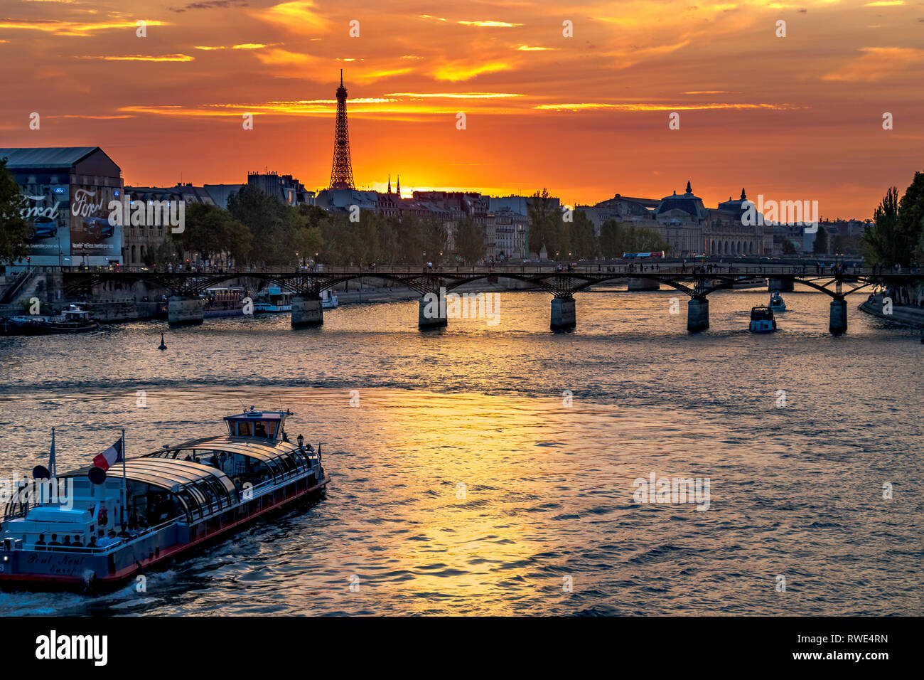 Paris und die seine, die bei Sonnenuntergang unter der Pont des Art fließt, mit dem Eiffelturm in der Ferne, Paris, Frankreich Stockfoto