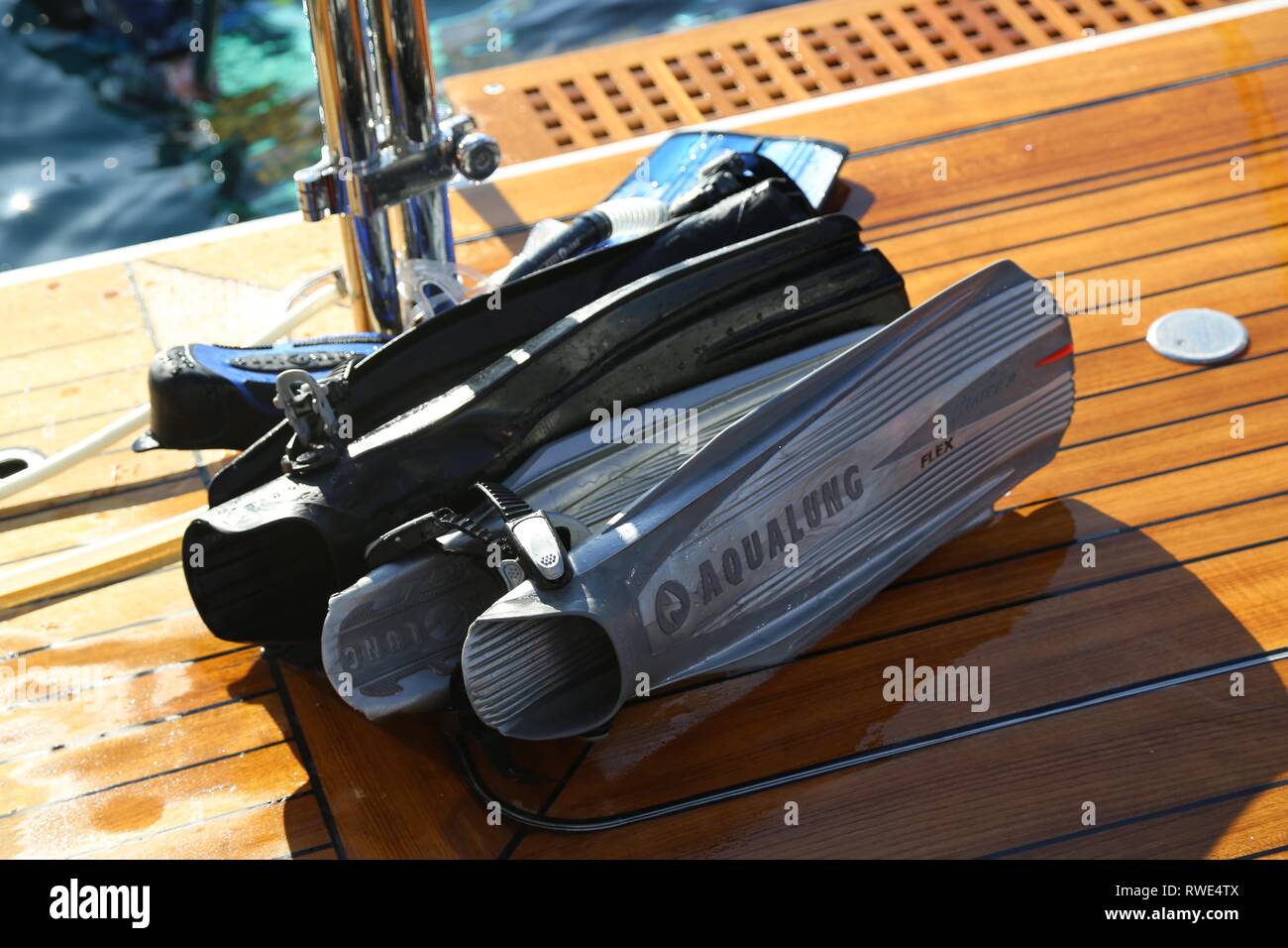 Nahaufnahme von Flossen und Taucherbrille auf hölzernen Deck des Bootes Stockfoto