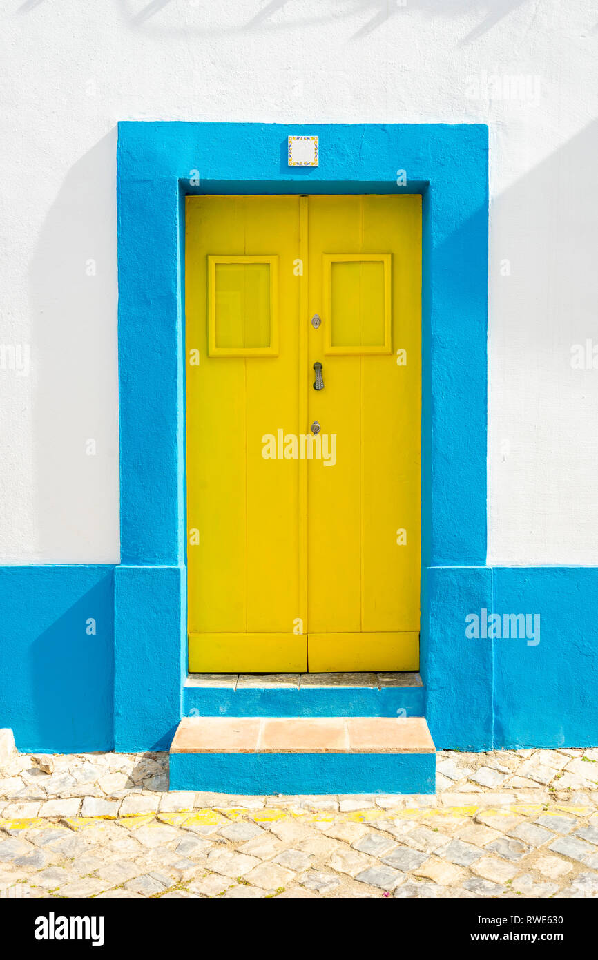 Gelbe Tür im traditionellen portugiesischen Haus auf Blau und Weiß, Tavira, Algarve lackiert Stockfoto