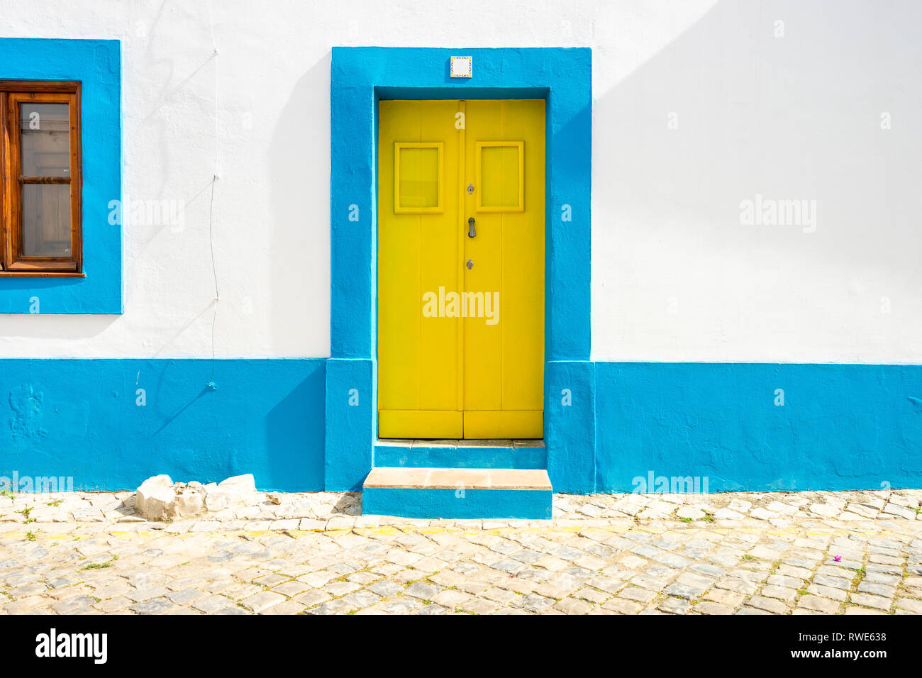 Gelbe Tür im traditionellen portugiesischen Haus auf Blau und Weiß, Tavira, Algarve lackiert Stockfoto