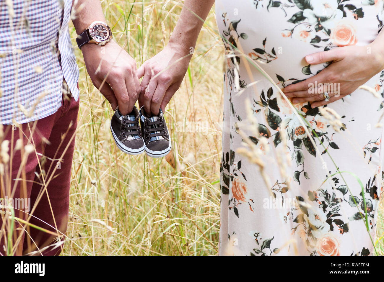 Erwartet Paar halten Baby Schuhe im Beacon Hill Park in Victoria, British Columbia. Stockfoto