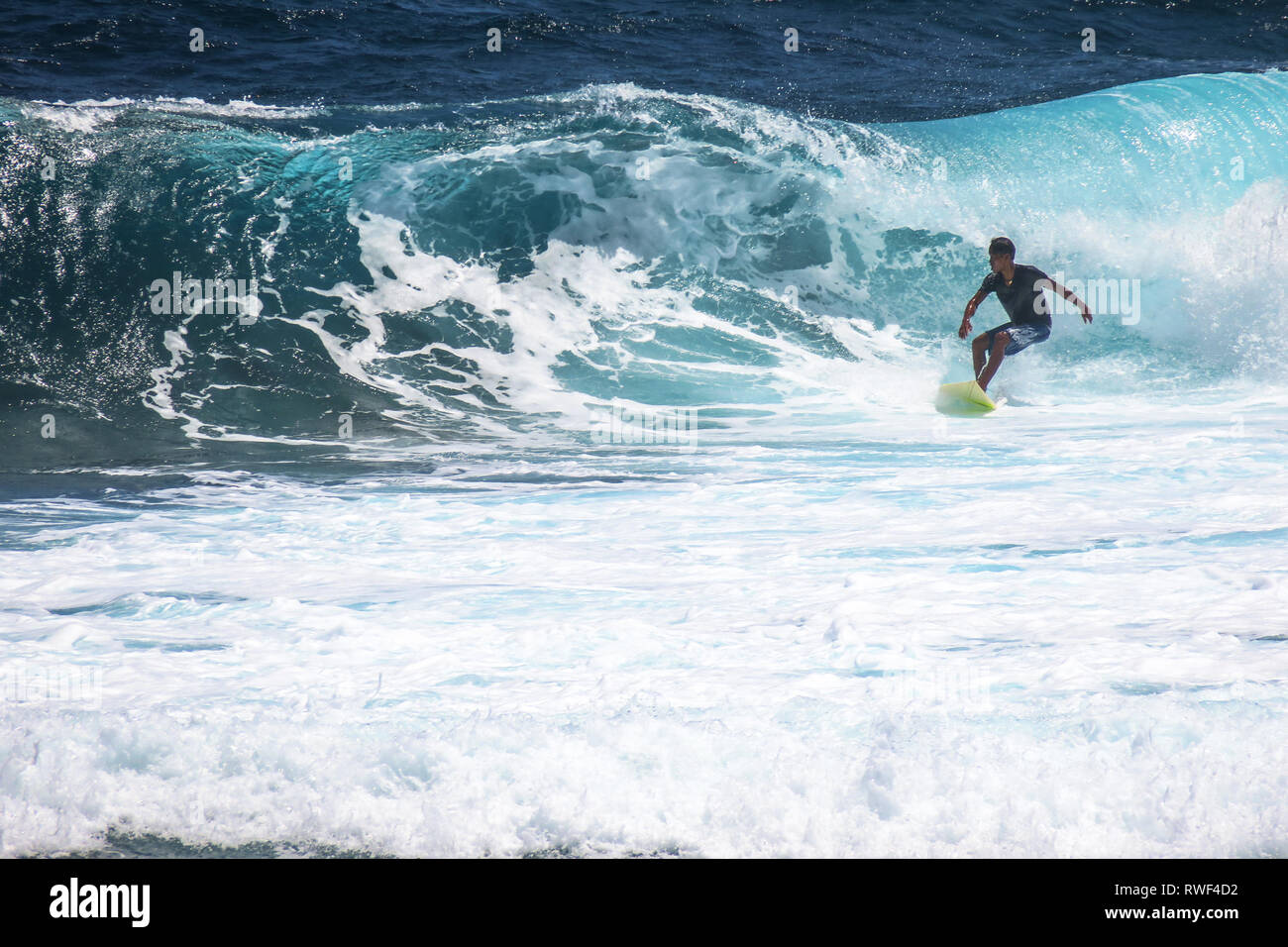 Man Surfen Blue Wave auf Wolke 9 - Siargao, Philippinen Stockfoto
