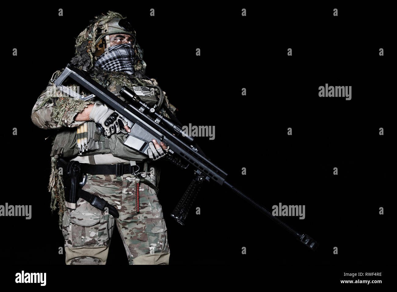 Army Sniper mit großen Gewehr stehend auf schwarzen Hintergrund. Stockfoto