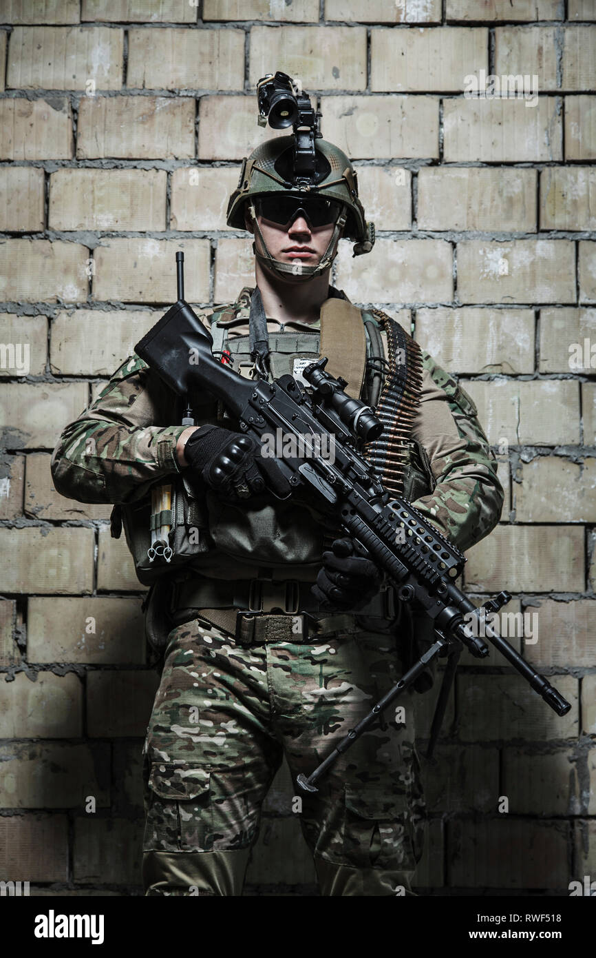 U.S. Army Ranger mit Maschinengewehr und Nachtsichtgerät in der Nähe einer Wand stehen. Stockfoto