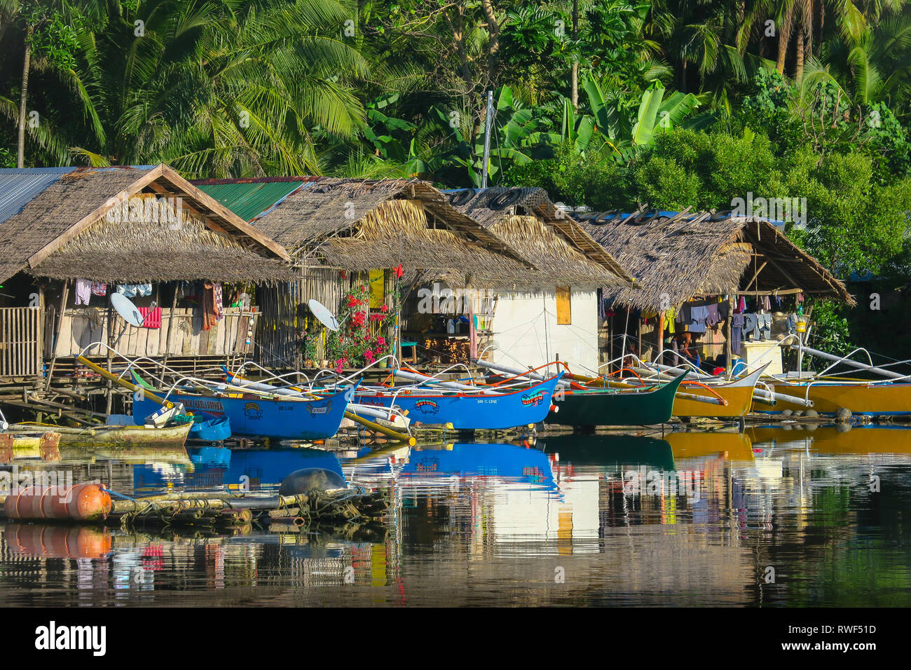 Bunte Boote aus Holz geparkt bei einheimischen Häusern im Rustikalen philippinische Dorf - Siargao, Philippinen Stockfoto