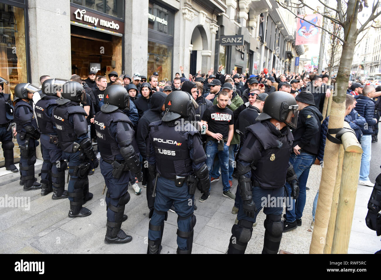 Ajax Fans sind vor Polizisten stehen auf der Hut vor dem Fußball März in Madrid gesehen. Fast 4.500 AJAX Fans reisten nach Madrid zu sehen der UEFA Champions League Spiel zwischen Real Madrid (Spanien) und Ajax Amsterdam (Holland). Unterstützer, die an den Plätzen in Madrid versammelt vor dem Spiel, verursachten Traffic Schnitte und warfen mit Flaschen und Bierdosen Touristenbusse. Stockfoto