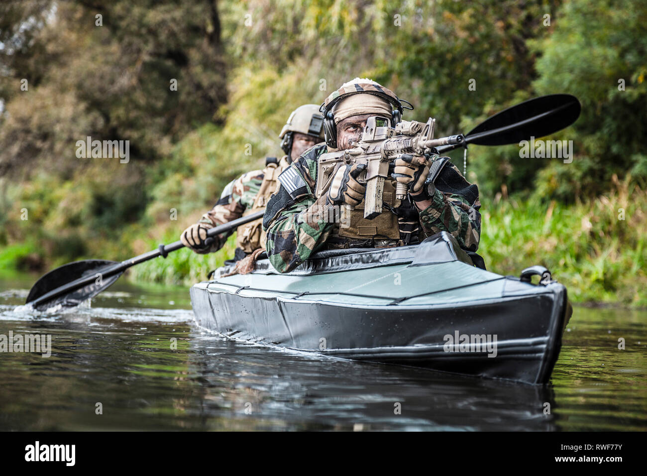 Special forces Männer paddeln Armee Kajak über den Fluss. Stockfoto