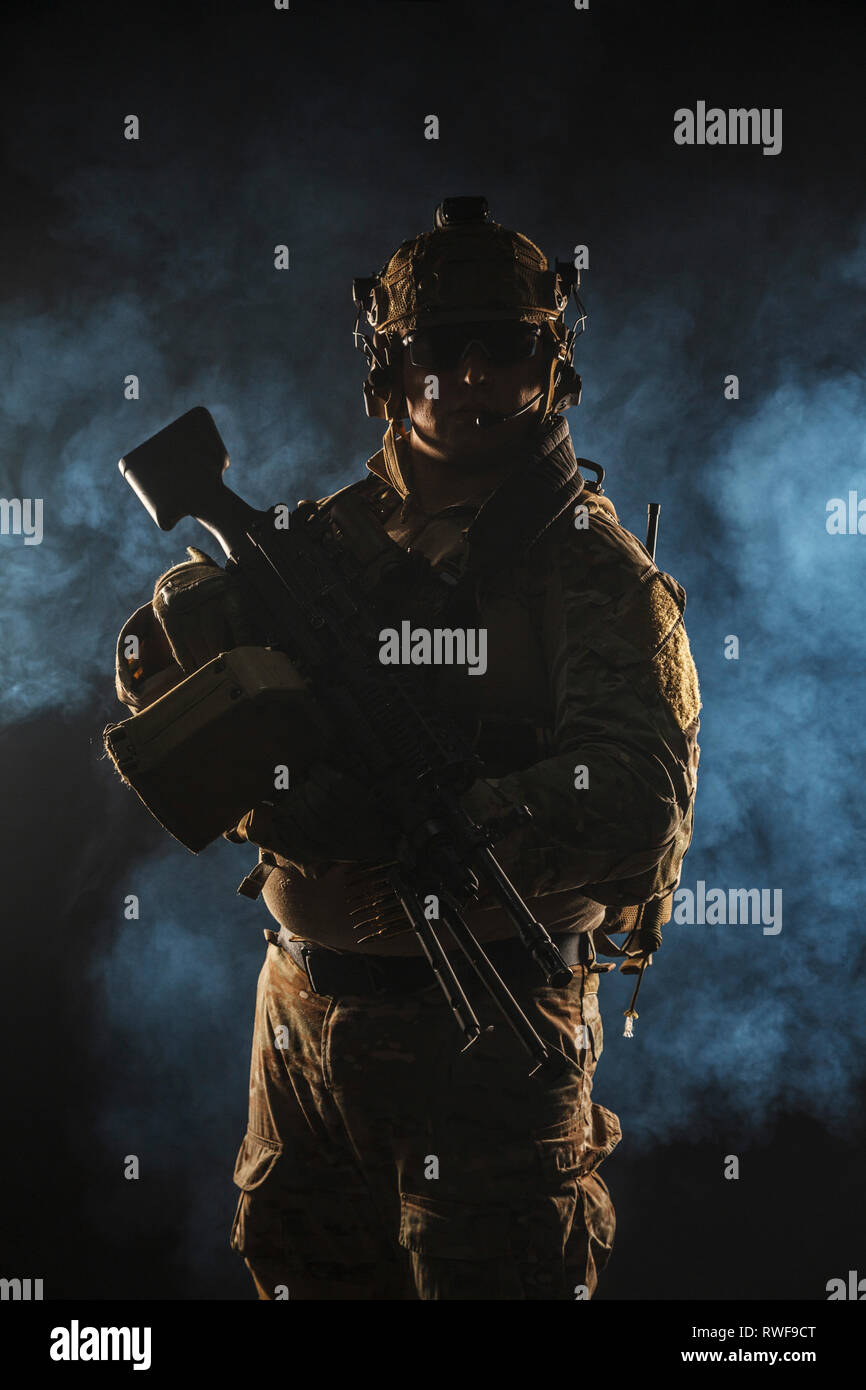 Armee Soldat im Kampf Uniform mit Maschinengewehr, der dunkle Rauch, den Hintergrund. Stockfoto