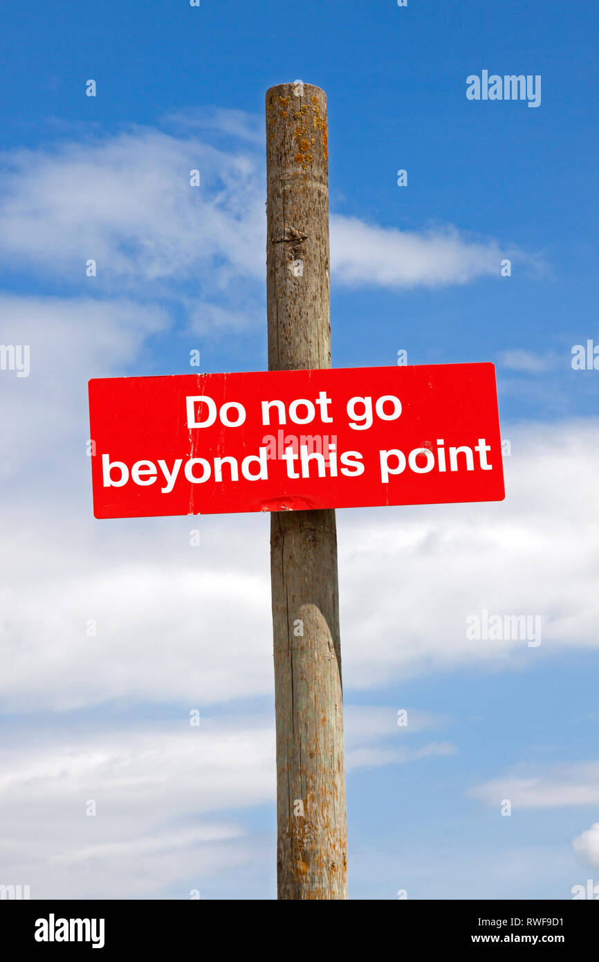 Ein Schild "Nicht über diesen Punkt hinaus" gegen einen blauen Himmel gesehen. Stockfoto