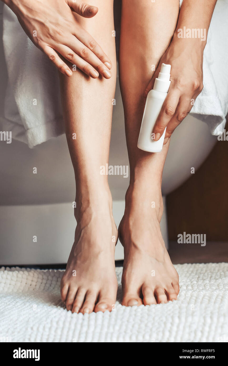 Körperpflege. Junge Frau im Badezimmer, ihre Beine streicheln. Anti-Krampfadern Pflege für schöne Beine Stockfoto
